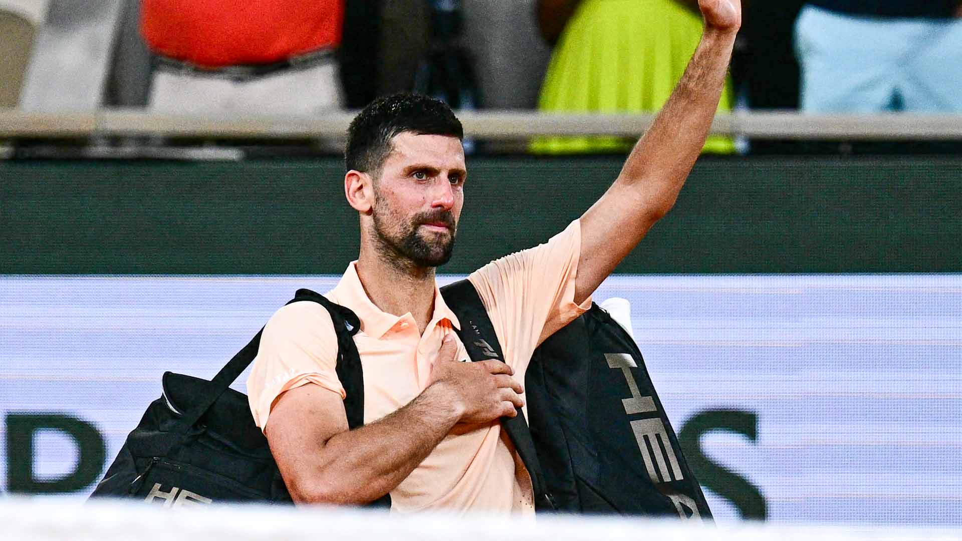 Novak Djokovic waves to the crowd inside Court Philippe-Chatrier following his five-set defeat to Joao Fonseca Friday at Roland Garros.